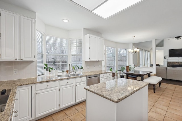 kitchen featuring sink, stainless steel dishwasher, hanging light fixtures, and white cabinets