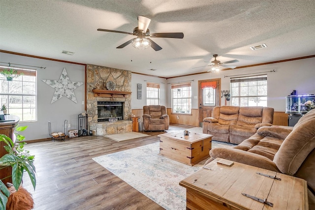 living room featuring ornamental molding, light hardwood / wood-style floors, and a healthy amount of sunlight