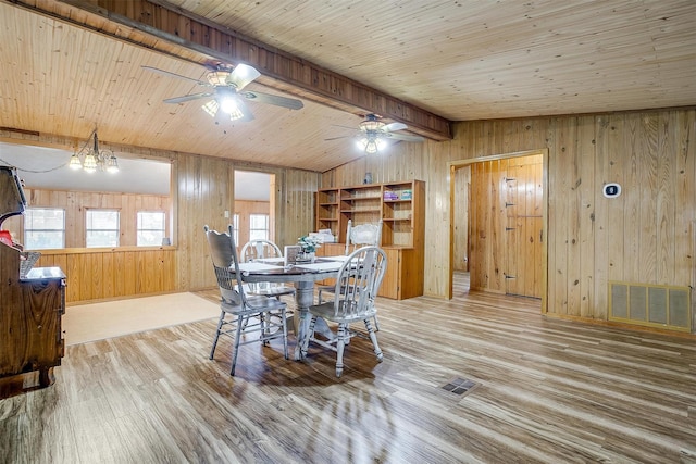 dining space with wood ceiling, vaulted ceiling with beams, hardwood / wood-style flooring, and wooden walls