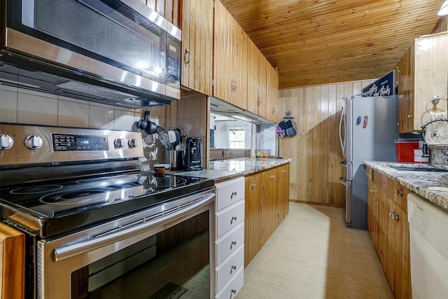 kitchen featuring sink, light hardwood / wood-style flooring, wooden ceiling, appliances with stainless steel finishes, and wooden walls