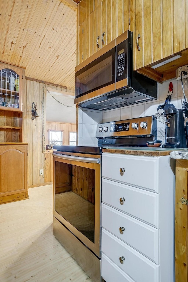 kitchen featuring stainless steel electric stove, wood walls, tasteful backsplash, wood ceiling, and light hardwood / wood-style flooring