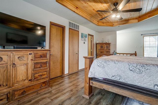 bedroom with multiple closets, hardwood / wood-style flooring, ceiling fan, a raised ceiling, and wooden ceiling