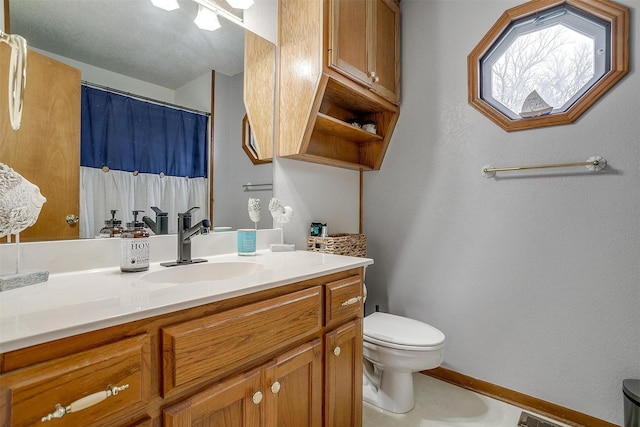 bathroom featuring vanity, toilet, and curtained shower