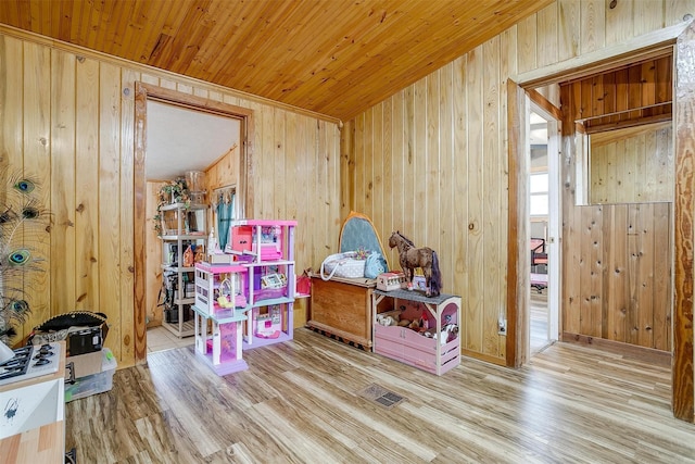 rec room featuring wood-type flooring, wooden ceiling, and wood walls