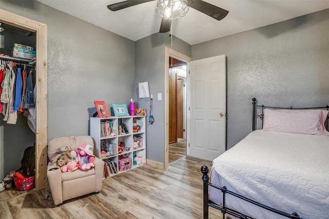 bedroom with a closet, ceiling fan, and light wood-type flooring