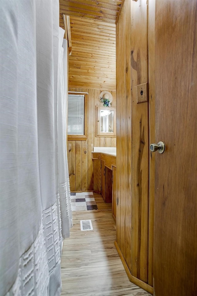 bathroom with vanity, wooden walls, hardwood / wood-style floors, and wooden ceiling