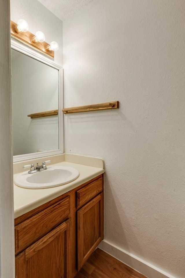 bathroom with hardwood / wood-style flooring, vanity, and a textured ceiling