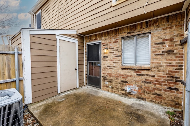 view of exterior entry with cooling unit and a patio area