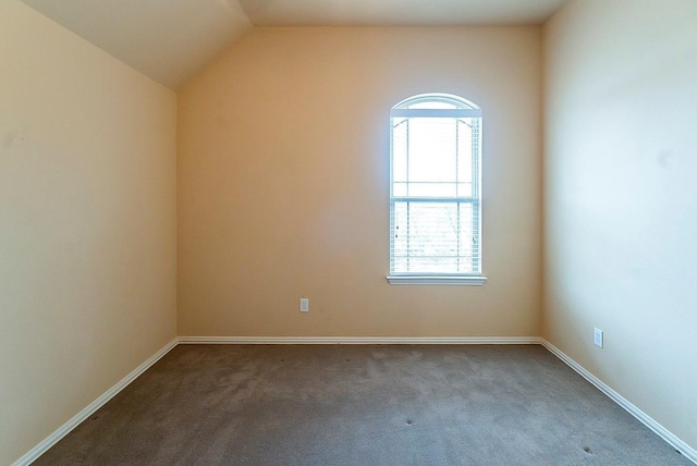 carpeted spare room with lofted ceiling