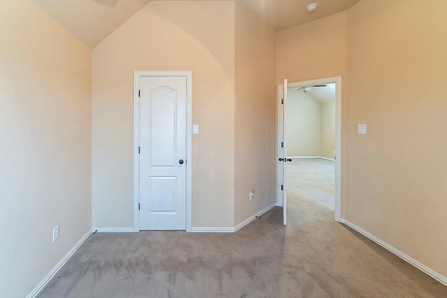 carpeted spare room with lofted ceiling