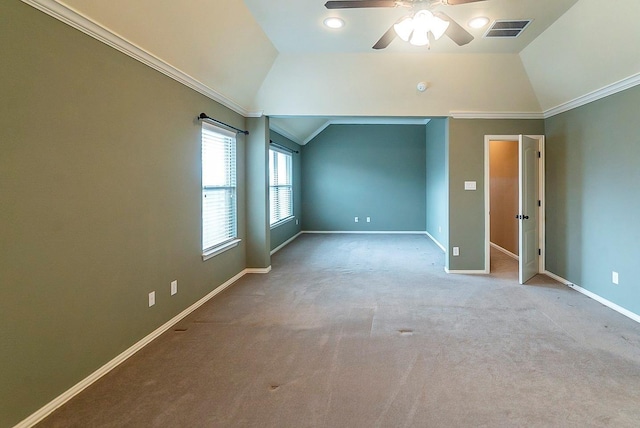 carpeted empty room featuring vaulted ceiling, ornamental molding, and ceiling fan