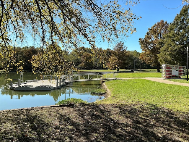 view of community with a water view and a lawn