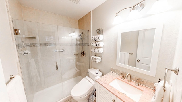 bathroom featuring vanity, toilet, and an enclosed shower