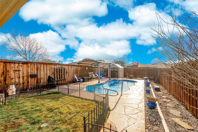 view of swimming pool with a storage shed, a yard, and a patio area