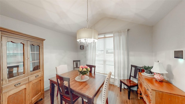 dining room featuring lofted ceiling and light hardwood / wood-style flooring