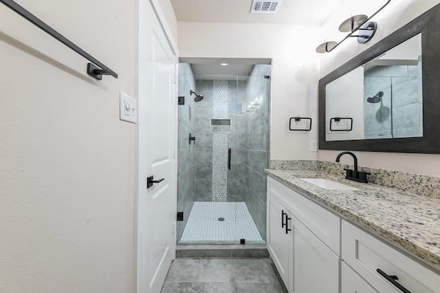 bathroom featuring vanity and a shower with shower door