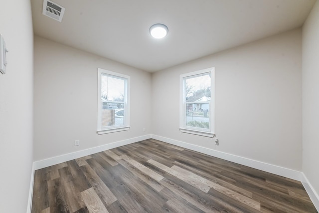 unfurnished room featuring dark wood-type flooring and a wealth of natural light