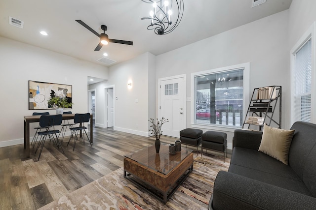 living room with hardwood / wood-style flooring and ceiling fan with notable chandelier