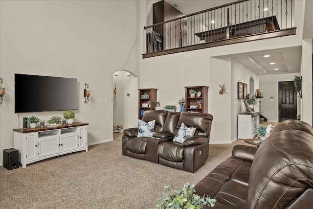 living room with carpet floors and a towering ceiling