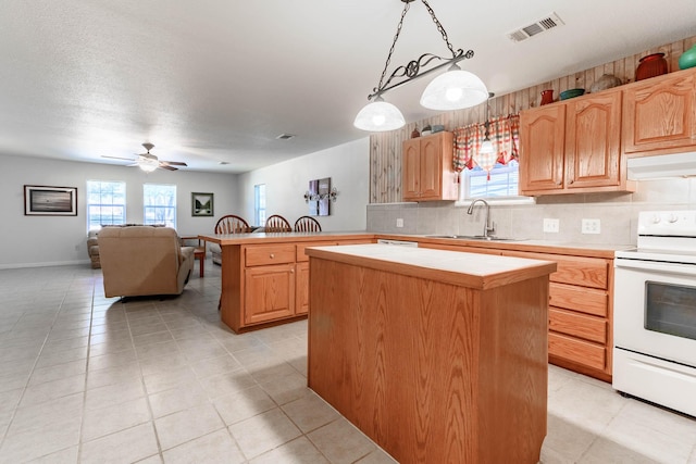 kitchen featuring tasteful backsplash, hanging light fixtures, a kitchen island, and electric range