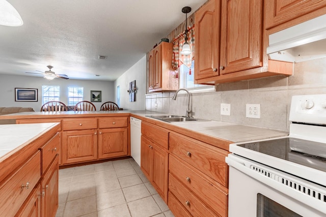 kitchen featuring sink, tile countertops, decorative light fixtures, kitchen peninsula, and white appliances