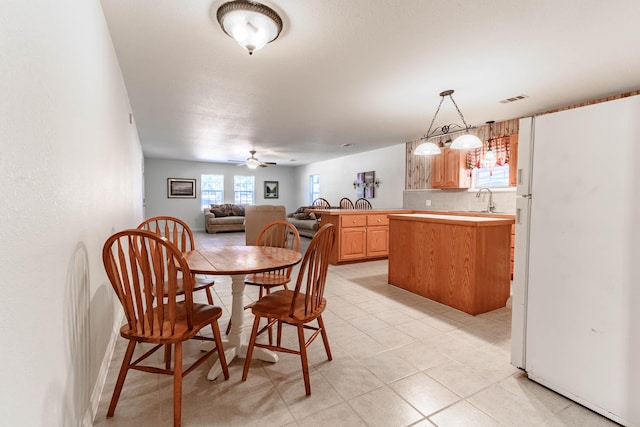 dining room featuring light tile patterned flooring, sink, and ceiling fan