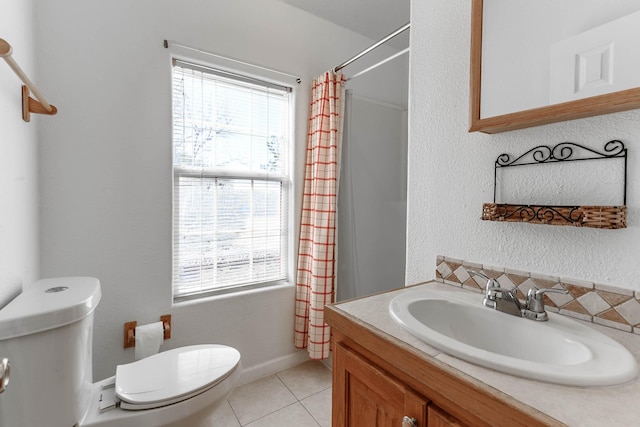 bathroom with tile patterned flooring, vanity, plenty of natural light, and toilet