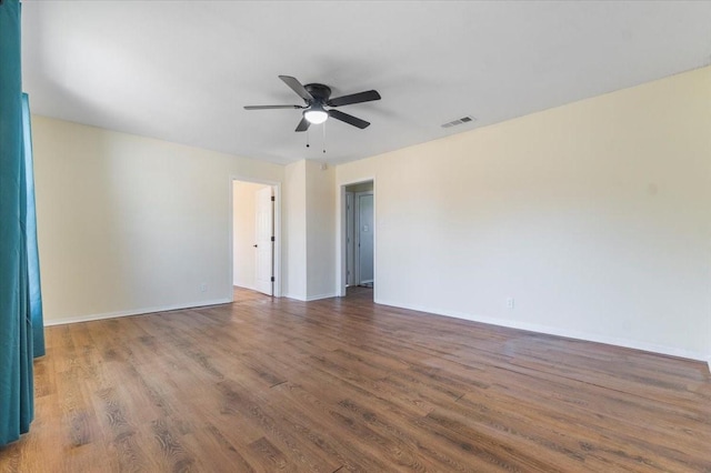 unfurnished room featuring dark wood-type flooring and ceiling fan