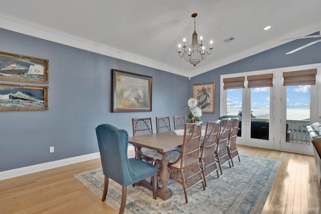 dining area featuring vaulted ceiling, light wood-type flooring, crown molding, and a chandelier