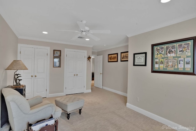 sitting room featuring crown molding, ceiling fan, and light carpet