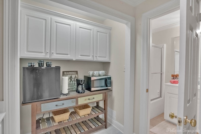 interior space featuring white cabinetry, crown molding, and light tile patterned flooring