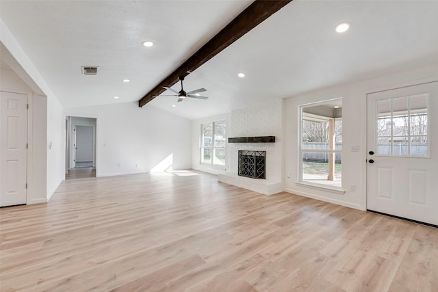 unfurnished living room with ceiling fan, light wood-type flooring, a brick fireplace, and vaulted ceiling with beams