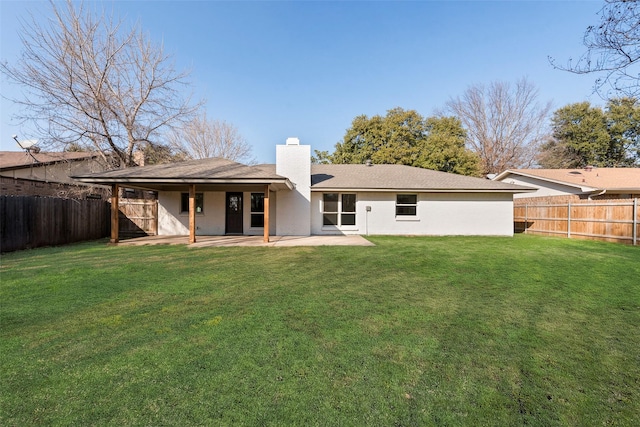 back of property with a lawn and a patio area