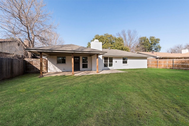 back of house with a yard and a patio