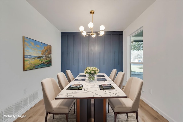 dining area with a notable chandelier and light wood-type flooring