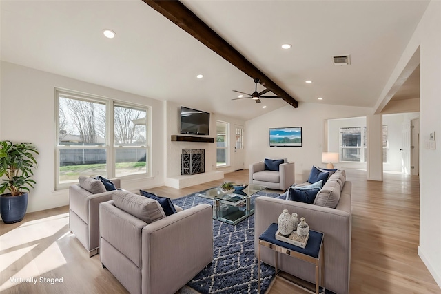 living room featuring lofted ceiling with beams, ceiling fan, and light wood-type flooring