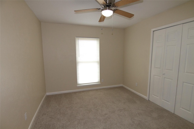 unfurnished bedroom with light colored carpet, ceiling fan, and a closet