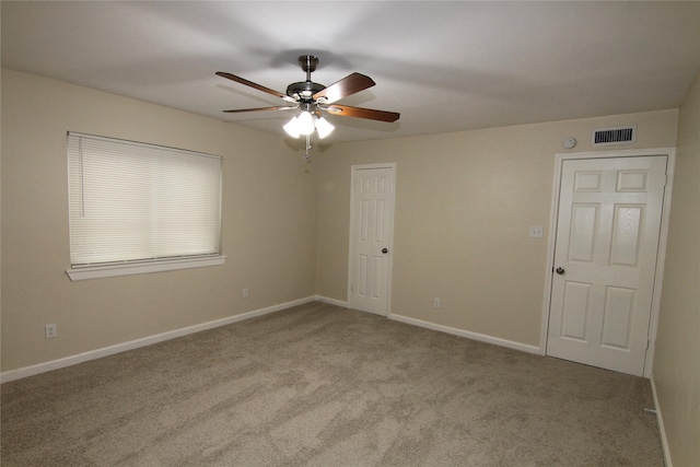 carpeted spare room with ceiling fan