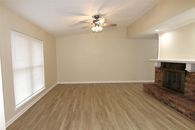 unfurnished living room with a brick fireplace, light hardwood / wood-style floors, and ceiling fan