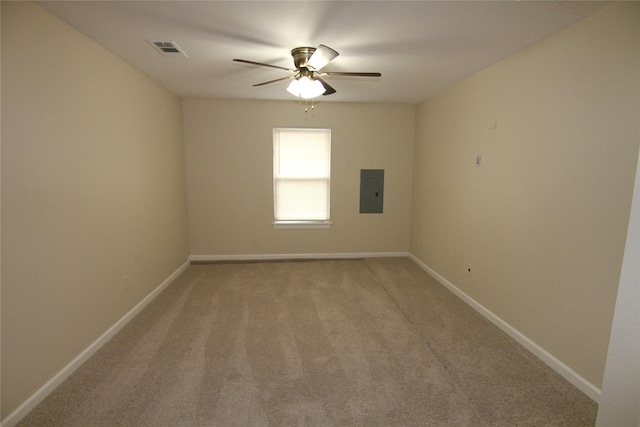 spare room featuring ceiling fan, electric panel, and carpet