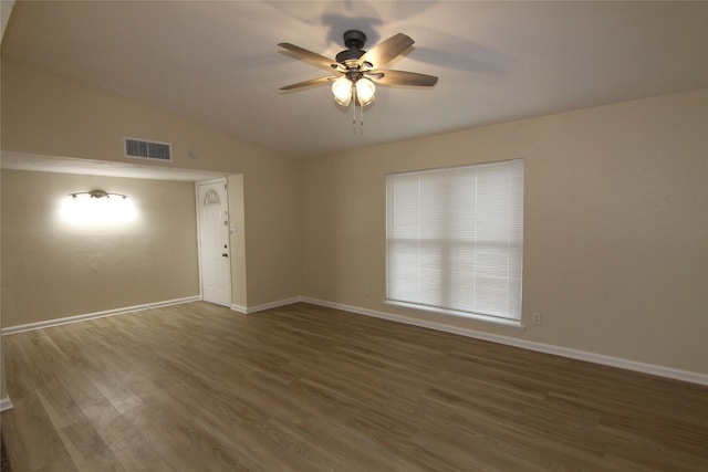 empty room with dark wood-type flooring, ceiling fan, and vaulted ceiling