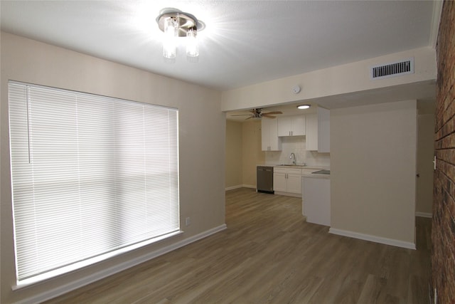 kitchen featuring dark wood-type flooring, sink, stainless steel dishwasher, ceiling fan, and white cabinets