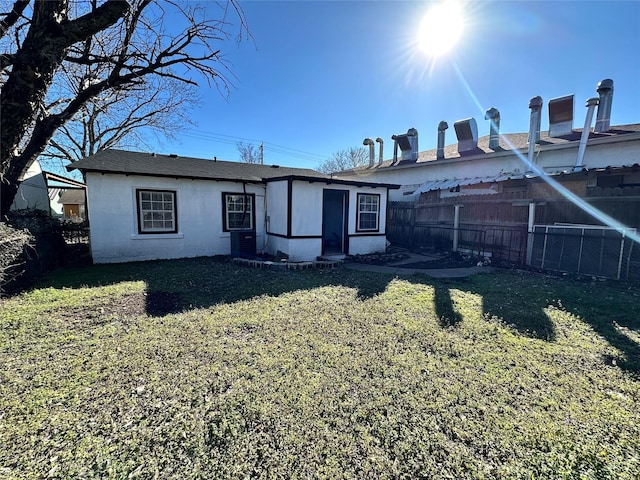 rear view of house with a yard and central AC