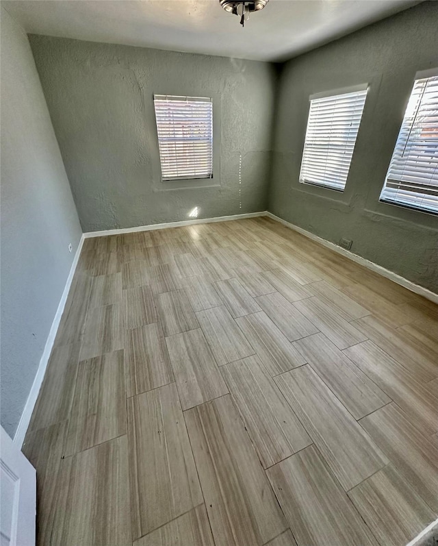 unfurnished room with light hardwood / wood-style flooring and a wealth of natural light