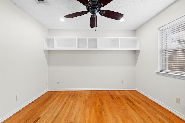 unfurnished room with hardwood / wood-style flooring, ceiling fan, and a textured ceiling