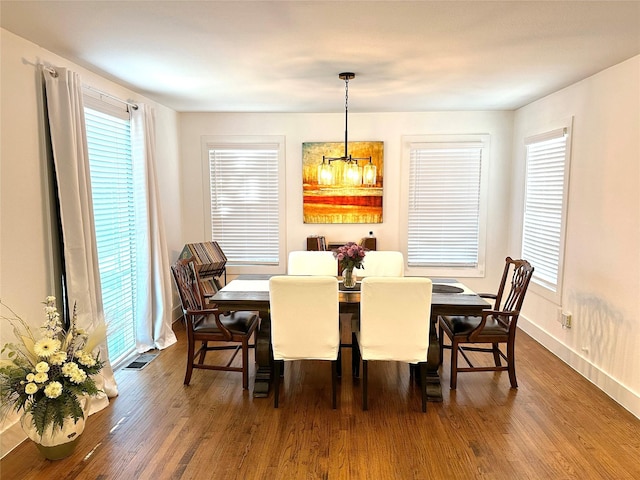 dining area with plenty of natural light, visible vents, and dark wood-style flooring