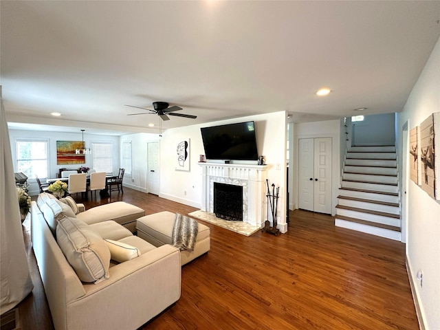 living area with ceiling fan, stairway, wood finished floors, a fireplace, and recessed lighting