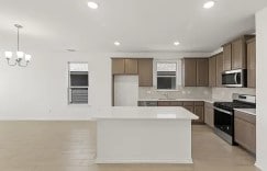 kitchen featuring recessed lighting, light countertops, appliances with stainless steel finishes, decorative backsplash, and decorative light fixtures