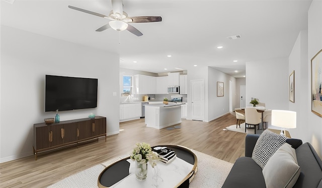 living area with baseboards, visible vents, ceiling fan, light wood-style floors, and recessed lighting