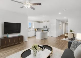 living room with ceiling fan and light hardwood / wood-style floors